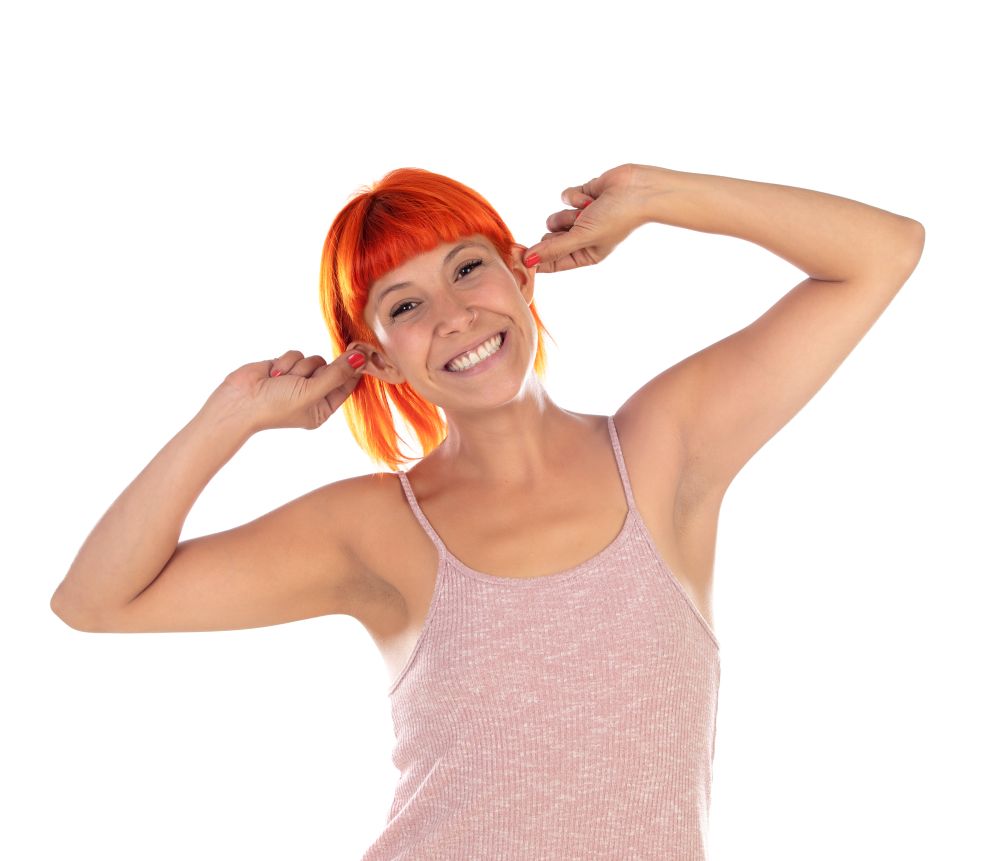 Woman with red hair covering her ears with the fingers isolated on a white background