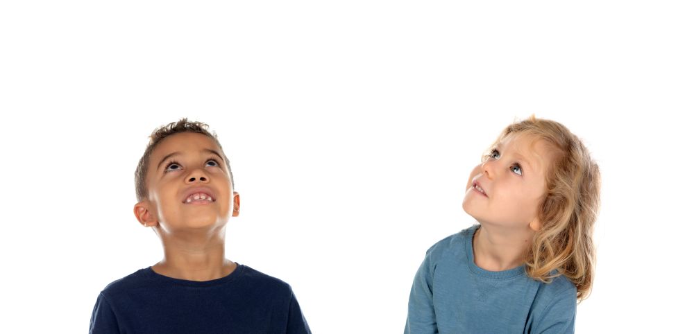 Two happy children looking up isolated on a white backround