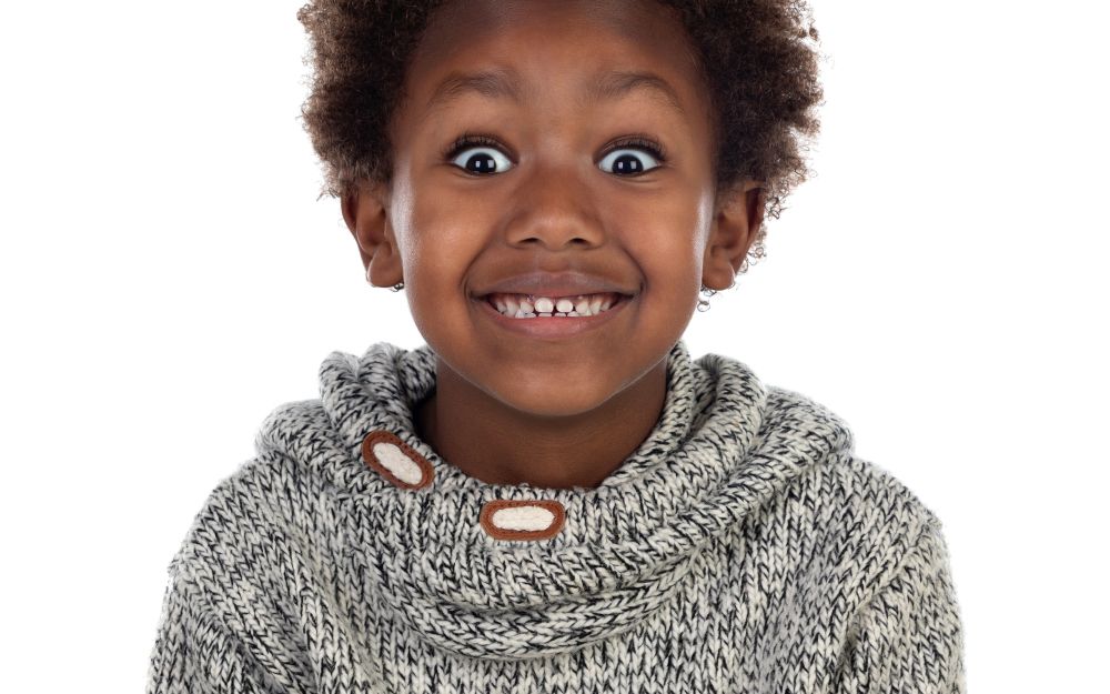 Funny expression of a small african child isolated on a white background