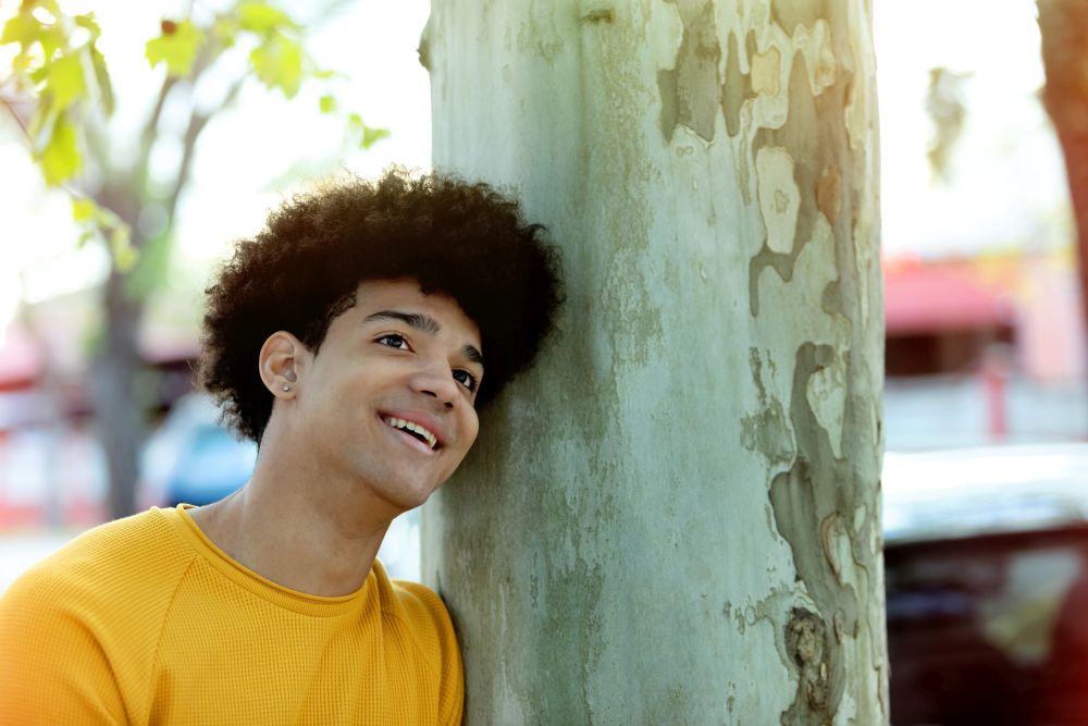 Pensive teenager with afro hairstyle in love on the street