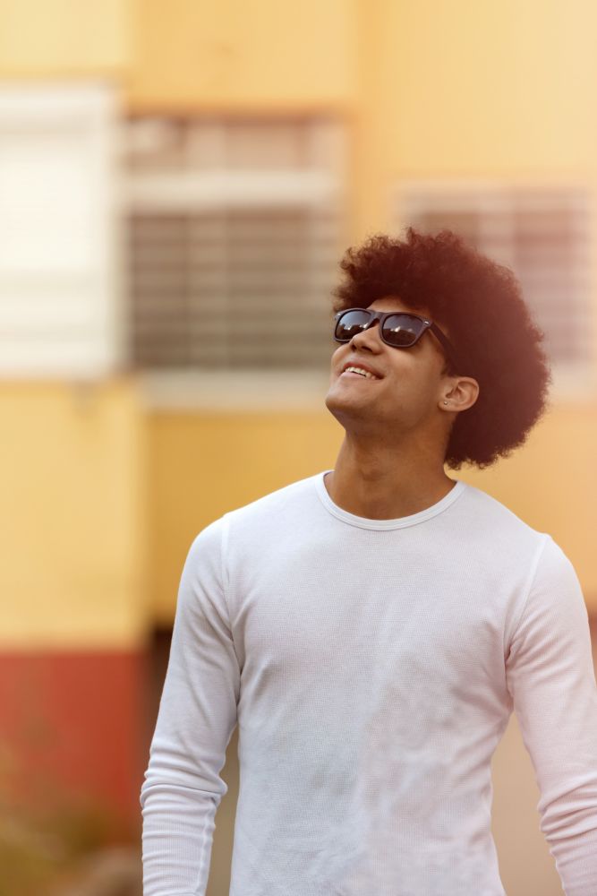 Handsome guy with afro hairstyle and sunglasses on the street