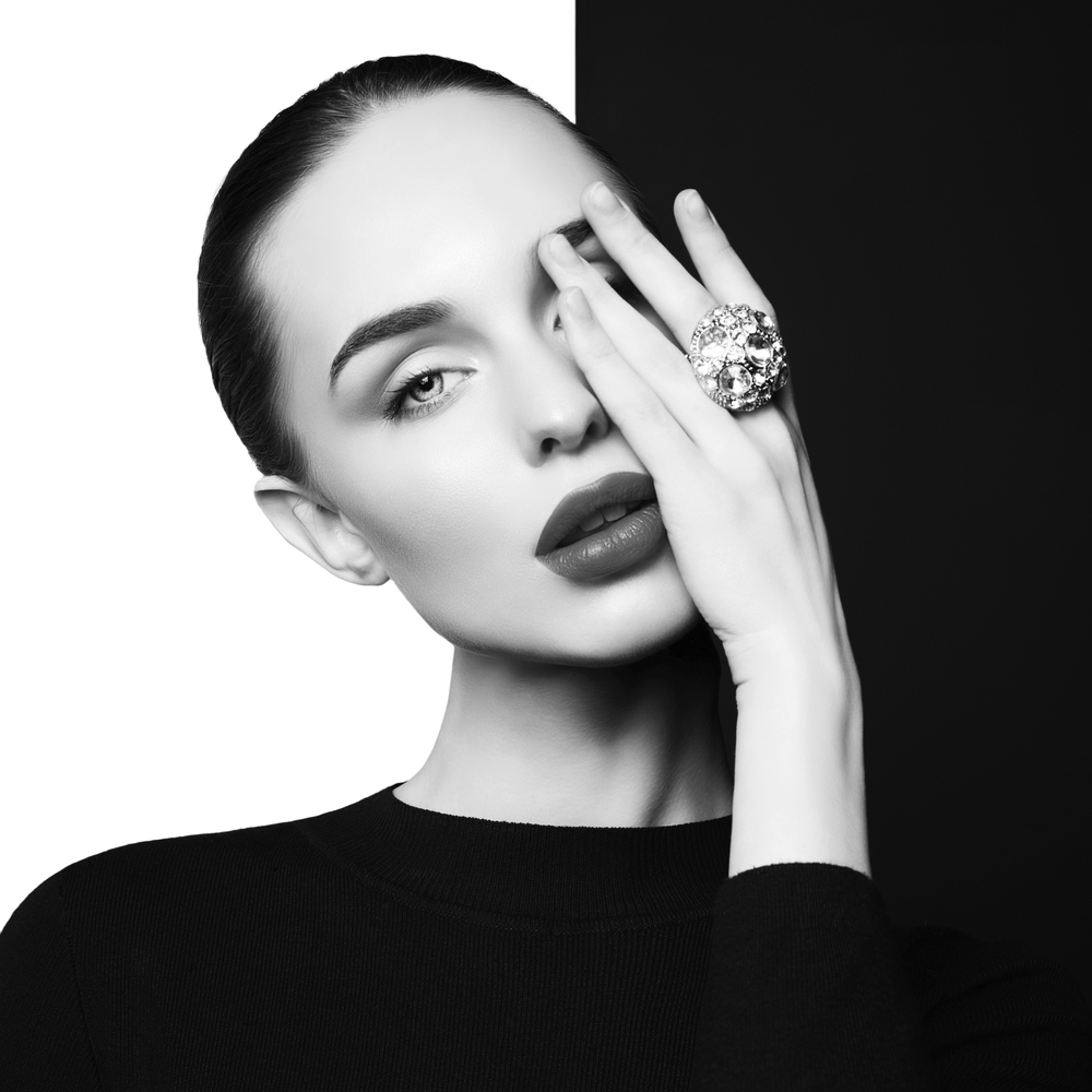 young sexy lady with big ring with diamonds in black-and-white studio. beautiful woman with perfect lips and black lipstick poses in photostudio. Fashion portrait of fashionable model.