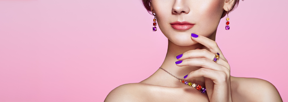 Portrait beautiful woman with jewelry. Model girl with violet manicure on nails. Beauty and Accessories. Pink lipstick