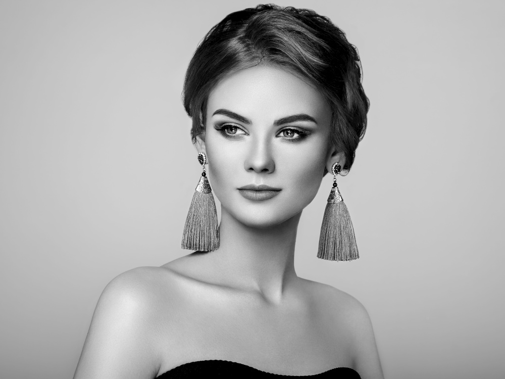 Beautiful Woman with Large Earrings Tassels jewelry. Perfect Makeup and Elegant Hairstyle. Make-up Arrows