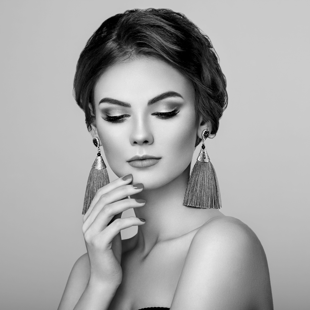 Beautiful Woman with Large Earrings Tassels jewelry. Perfect Makeup and Elegant Hairstyle. Nails manicure