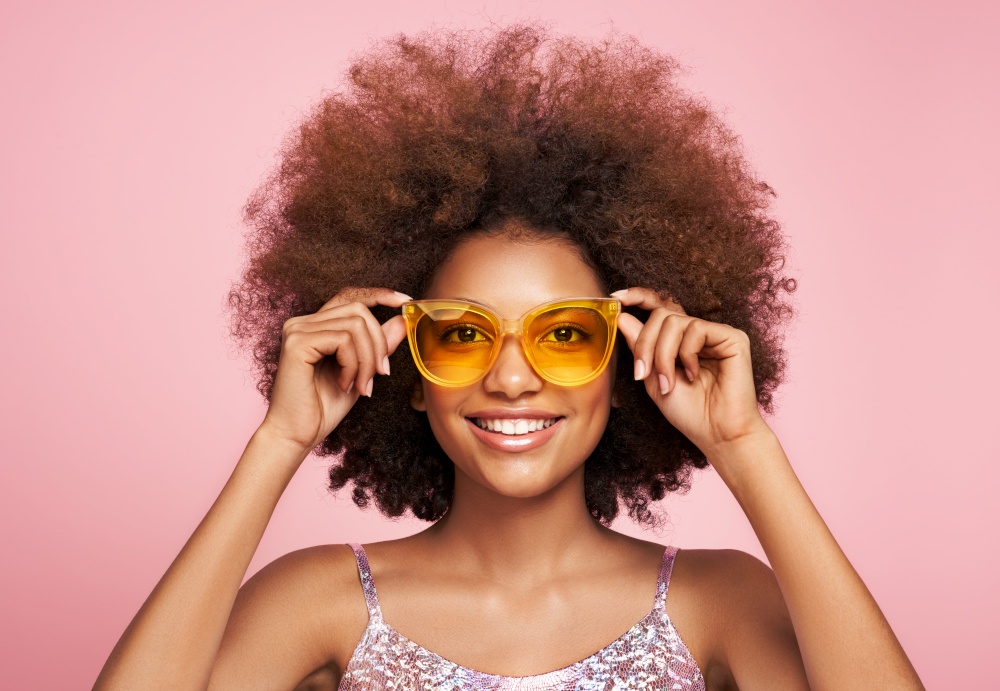 Beauty portrait of African American girl in colored sunglasses. Beautiful black woman. Cosmetics, makeup and fashion