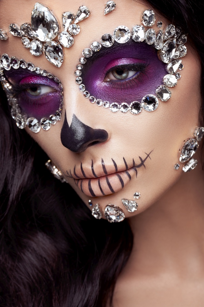 Portrait of a woman with sugar skull makeup. Halloween costume and make-up. Portrait of Calavera Catrina
