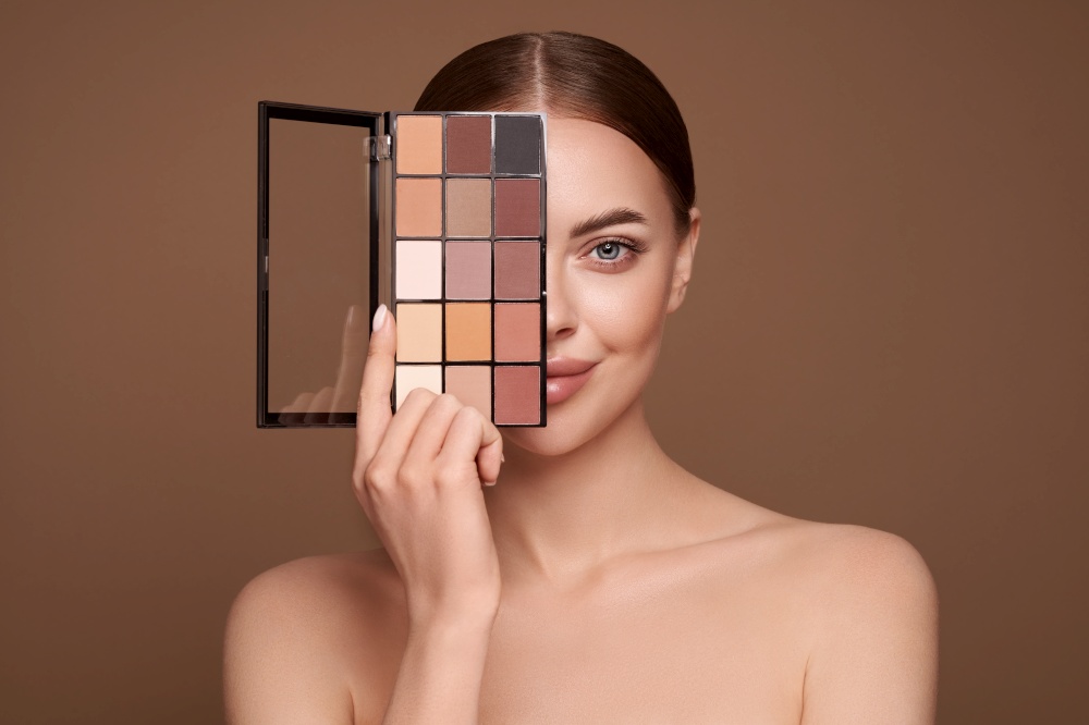 Beauty woman with eye shadow makeup palette. Model with healthy perfect skin, close up portrait. Cosmetology, beauty and spa