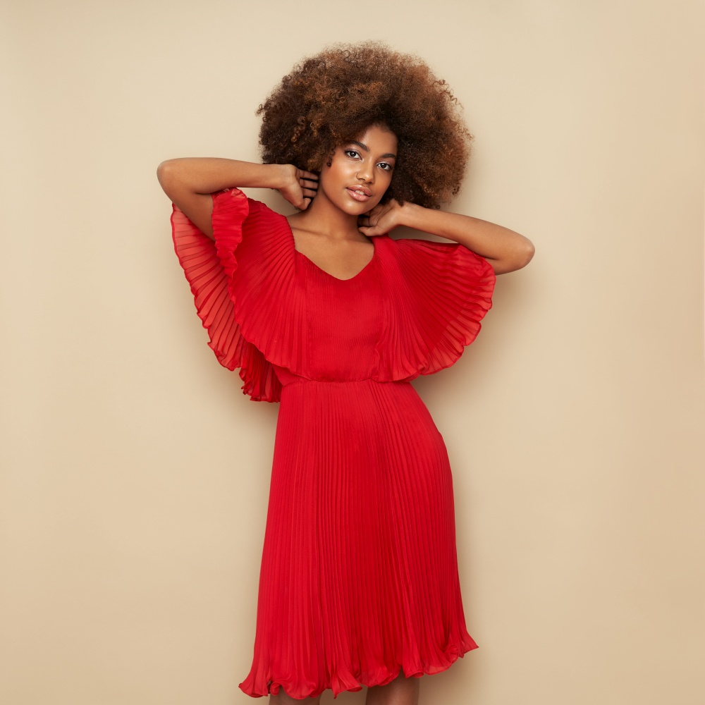 Beauty portrait of African American girl with afro hair. Beautiful black woman in red dress. Cosmetics, makeup and fashion