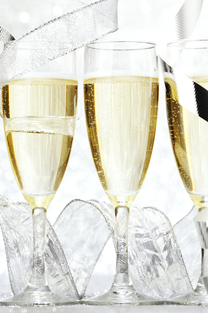 Glasses of champagne with bow on silver background