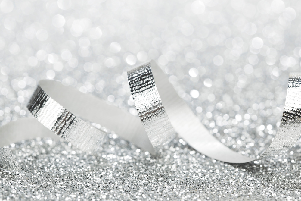 Shiny silver gift ribbon on bokeh background close-up