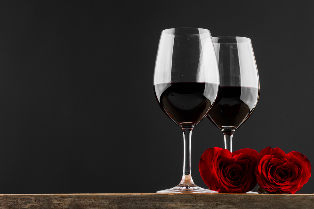 Two glasses of red wine and heart shaped roses, Valentine day. Wine and roses