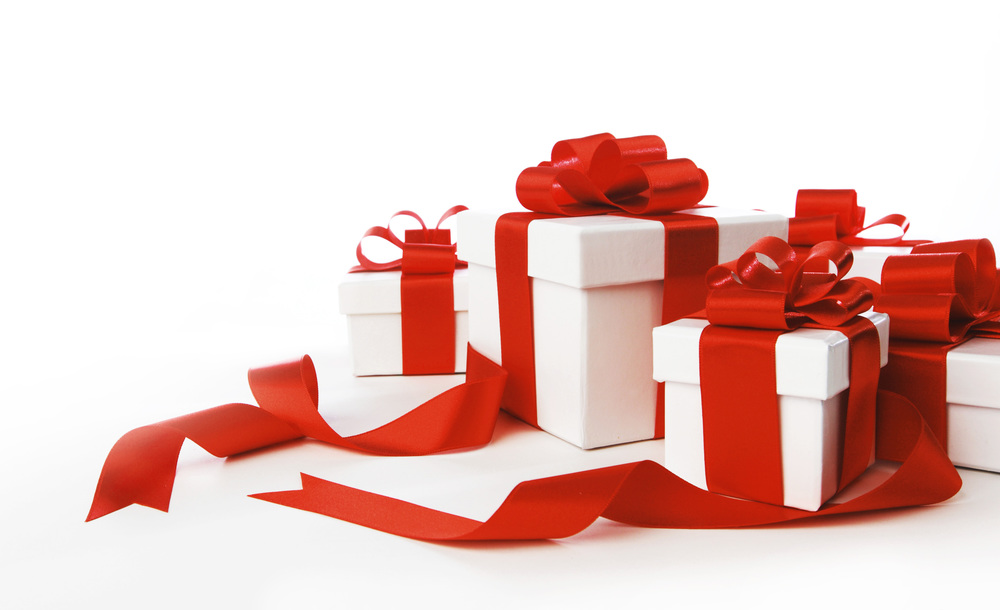 Boxes with presents wrapped in white paper with red ribbons, isolated on white
