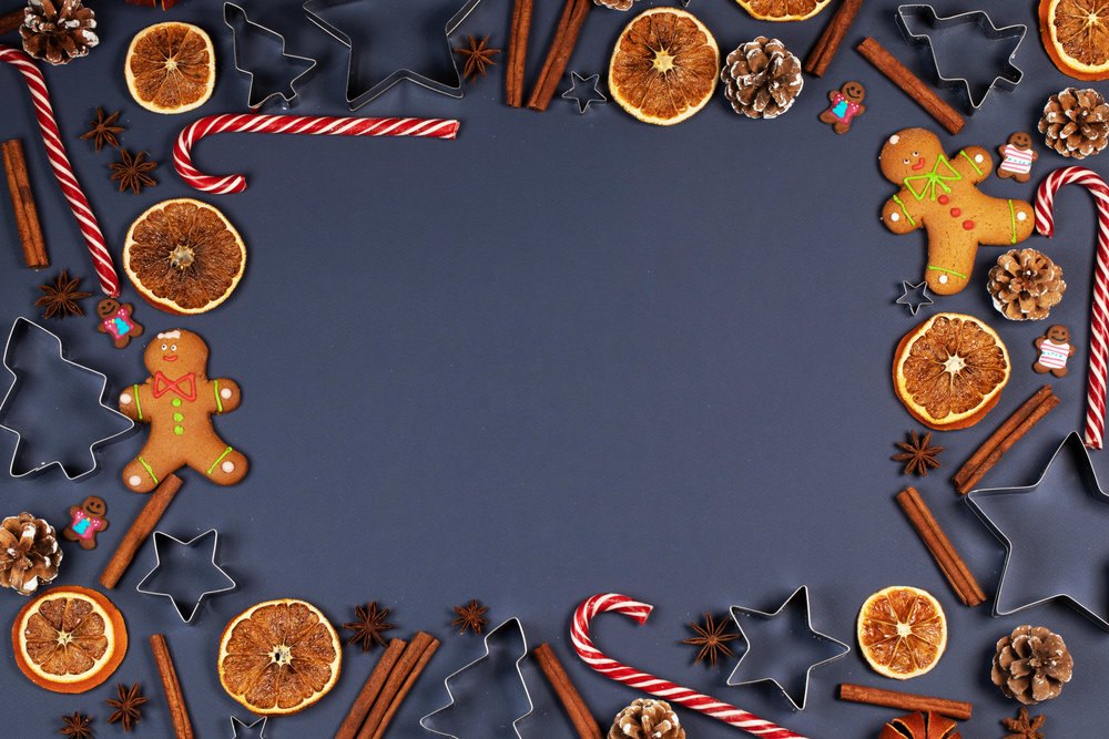 Christmas flat lay background with traditional gingerbread cookies dried orange cinnamon on blue, copy space for text. Christmas food on blue background