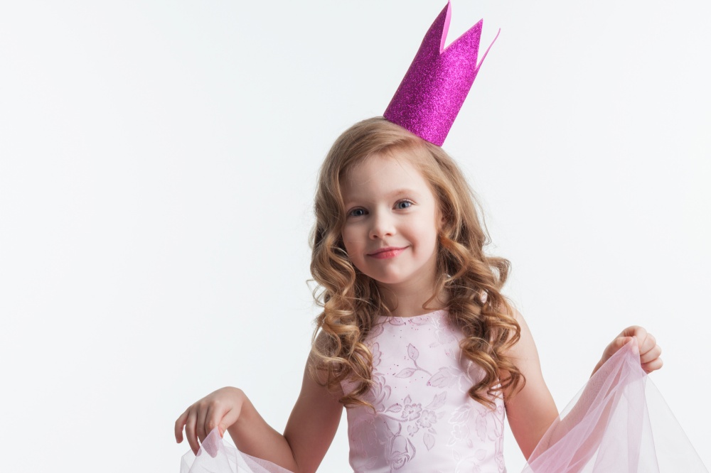 Little princess girl in pink crown and beautiful dress on white background. Little princess girl in pink