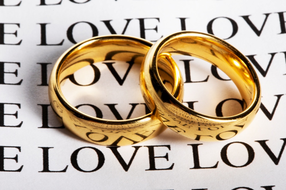 Two wedding rings made in gold and the word love. Two wedding rings and word love