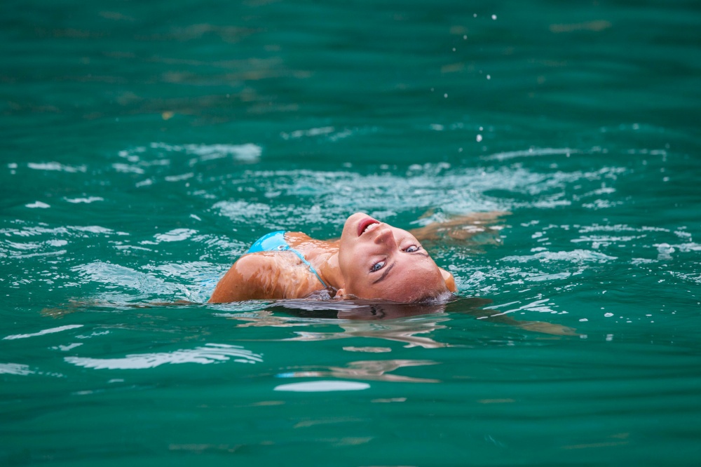 Girl relaxing floating in water of tropical sea. Girl relaxing in sea water
