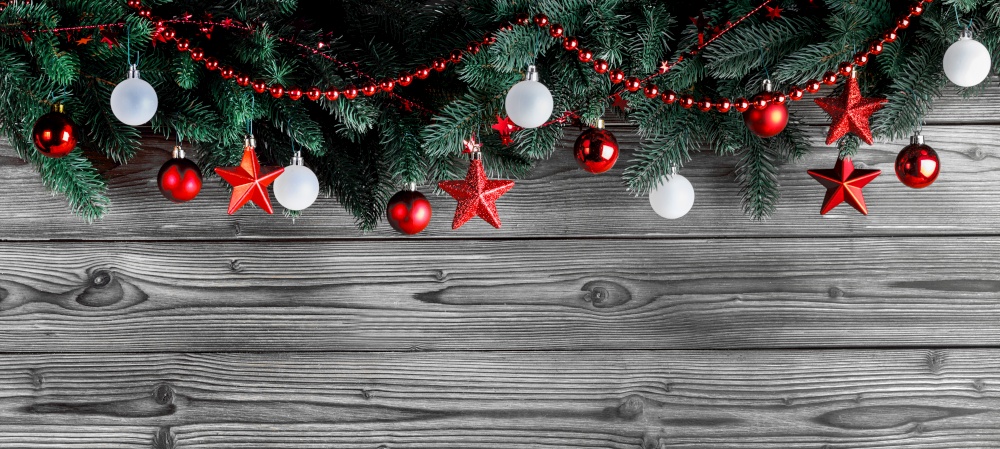 Christmas decoration with fir branches and red and white christmas balls on dark wooden background with copy space. Christmas decoration on wooden background