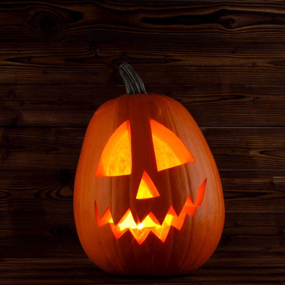 Jack o lantern Halloween pumpkin face on wooden background. Jack o lantern Halloween pumpkin