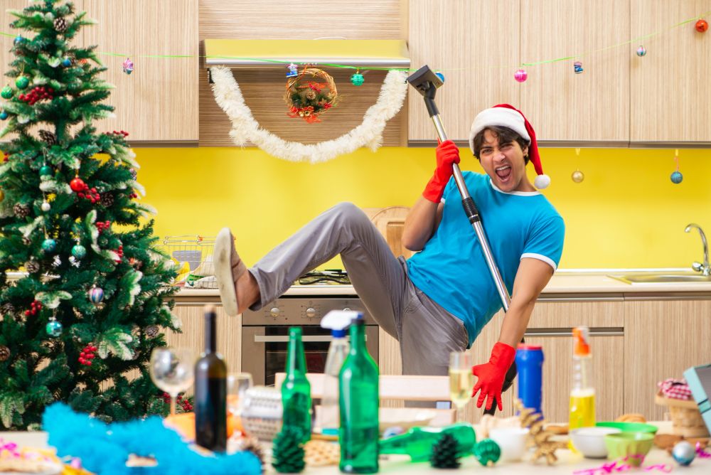 Young man cleaning kitchen after Christmas party