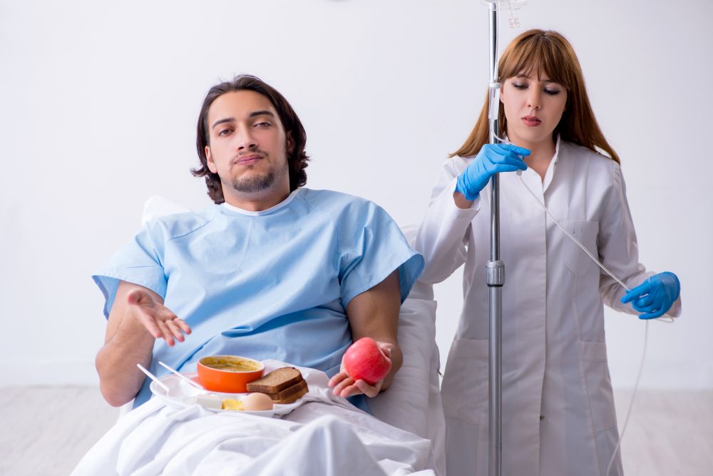 The male patient eating food in the hospital . Male patient eating food in the hospital