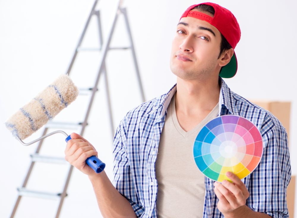 The young painter contractor choosing colors for home renovation. Young painter contractor choosing colors for home renovation