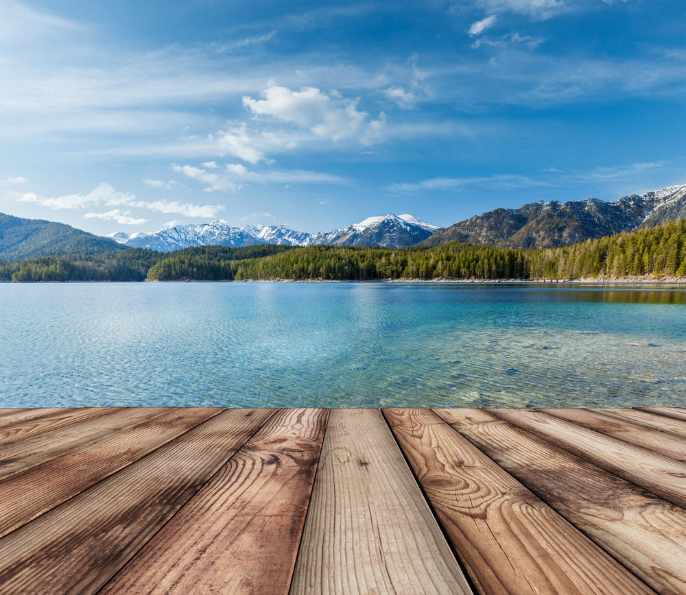 Wooden planks European nature background with lake in Alps, Germany. Wooden planks background with lake, Germany