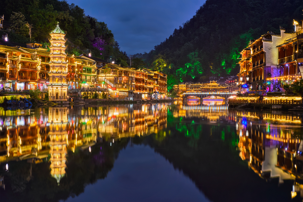 Chinese tourist attraction destination - Feng Huang Ancient Town (Phoenix Ancient Town) on Tuo Jiang River illuminated at night. Hunan Province, China. Feng Huang Ancient Town (Phoenix Ancient Town) , China