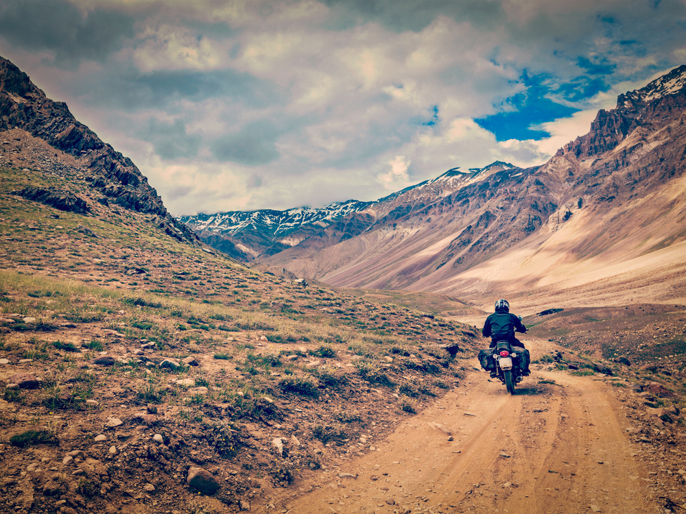 Vintage retro effect filtered hipster style image of motorcycle bike on mountain road in Himalayas. Spiti Valley, Himachal Pradesh, India. Bike on mountain road in Himalayas