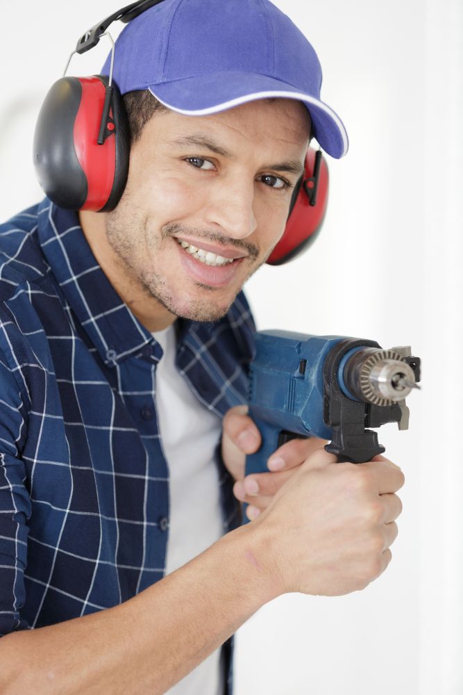 smiling handyman  holding drill in his hand