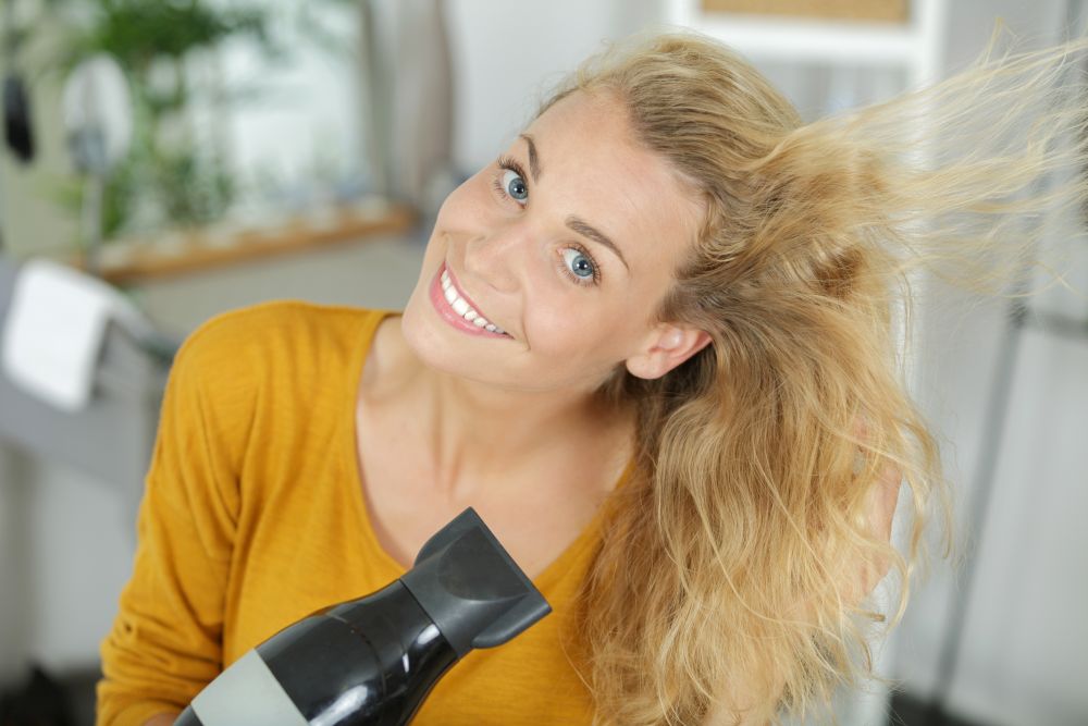 happy woman with a hairdryer