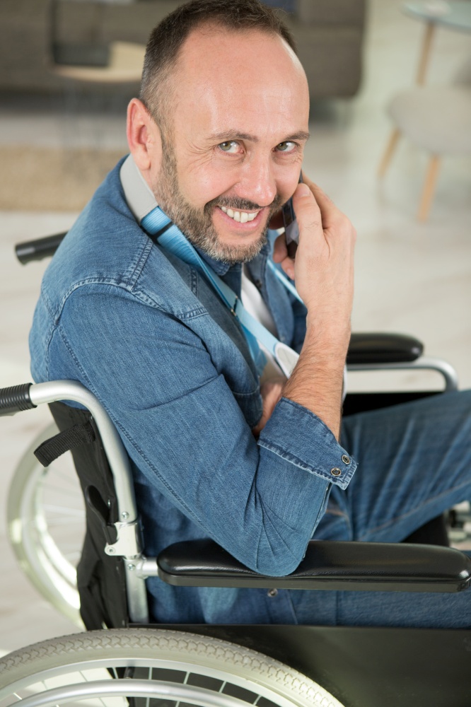 happy man on wheelchair working at home