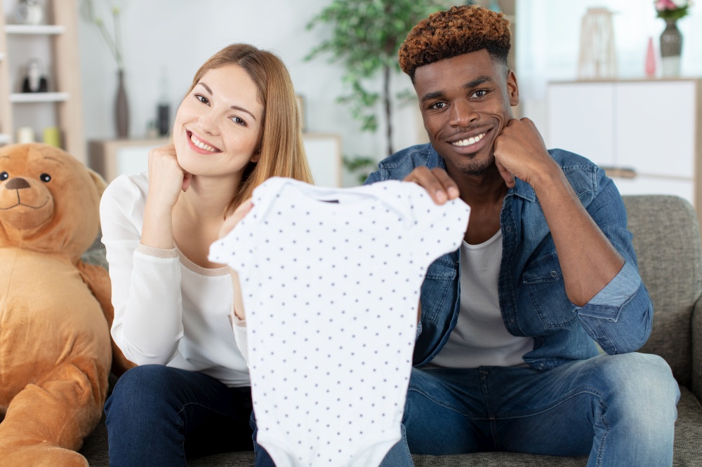 mixed couple showing baby cloths