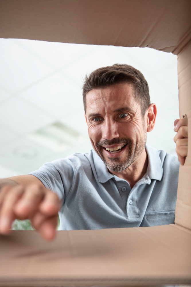 bearded man looking and reaching into cardboard box
