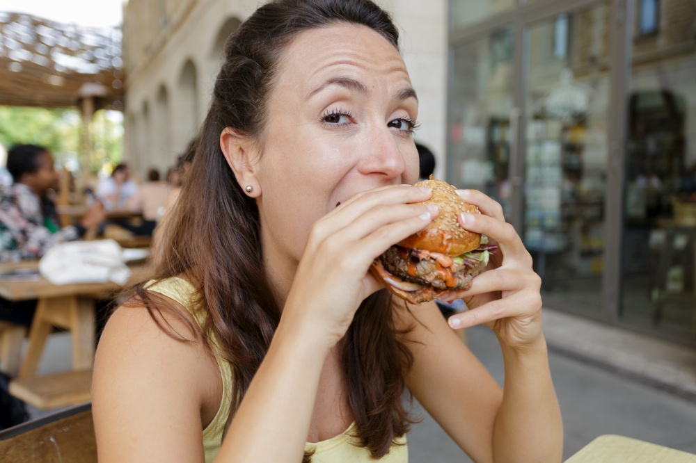 woman poised to bite into a burger