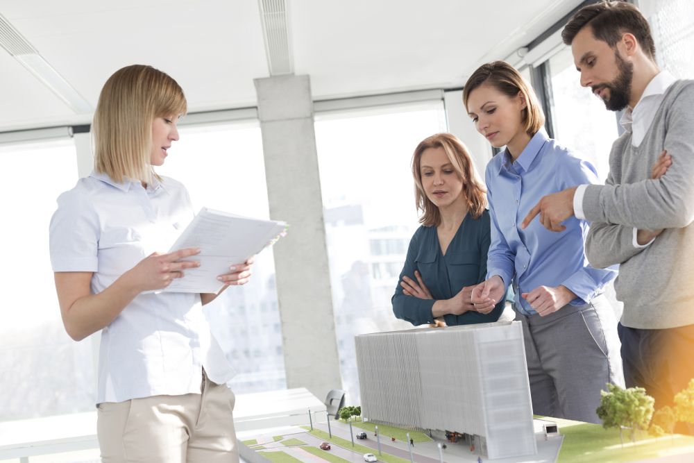 Businesswoman discussing over project with colleagues in office
