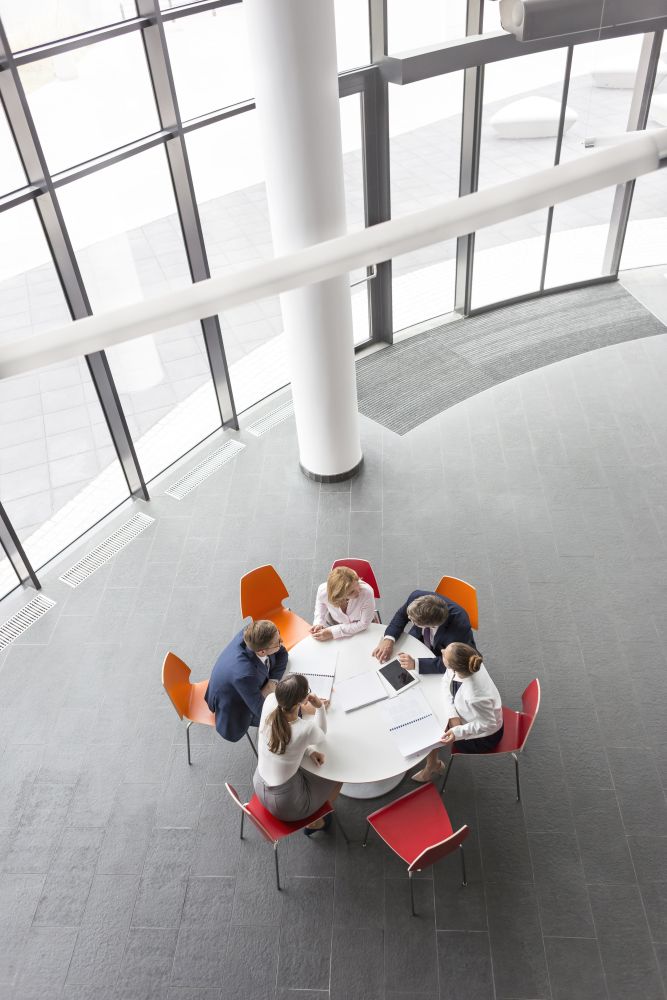 High angle view of business colleagues planning while sitting during meeting at office