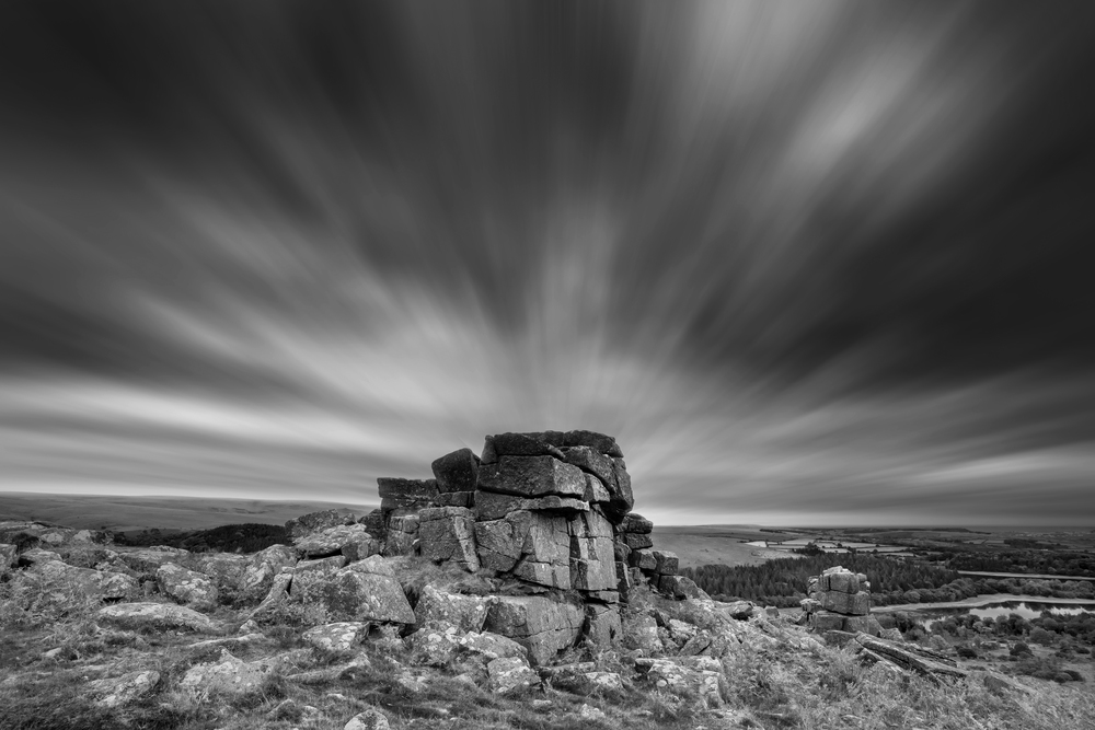 Beautiful Autumn sunset landscape image of view from Leather Tor in Dartmoor National Park in black and white