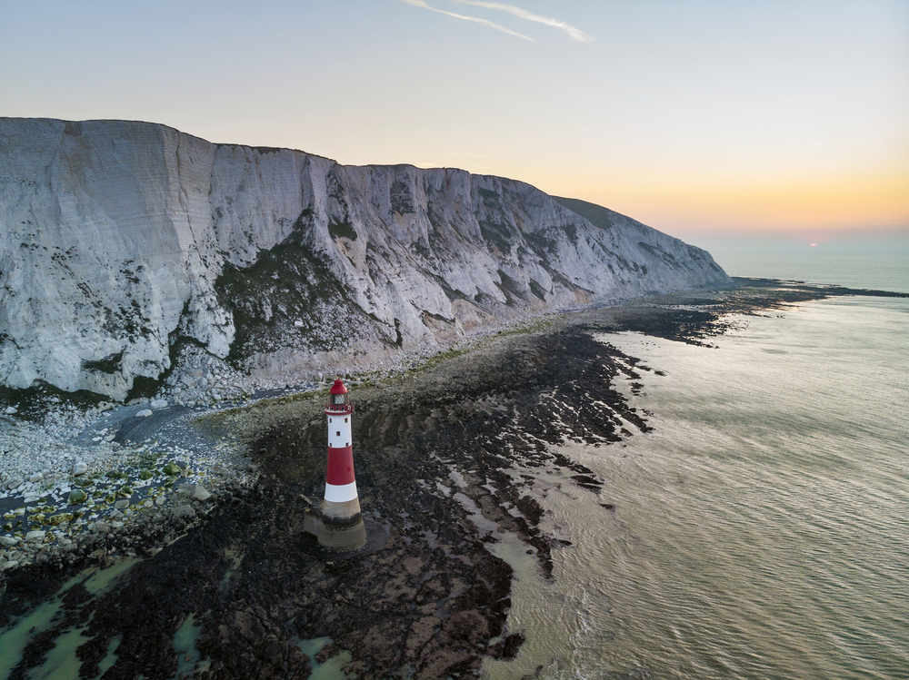 Aerial drone landscape image of lighthouse and chalk cliffs at sunrise in England