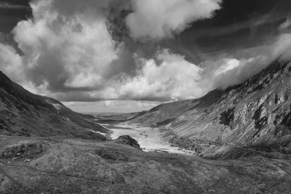Black and white Aerial view of flying drone Stunning epic landscape image in Autumn looking down Nant Fracon valley from Llyn Idwal dramatic sky and copy space