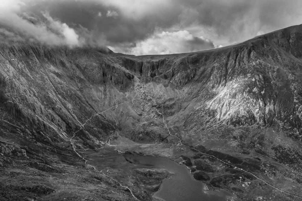 Black and white Aerial view of flying drone Epic stunning Autumn landscape image of Llyn Idwal in Devil&rsquo;s Kitchen in Snowdonia National Park with gorgeous light