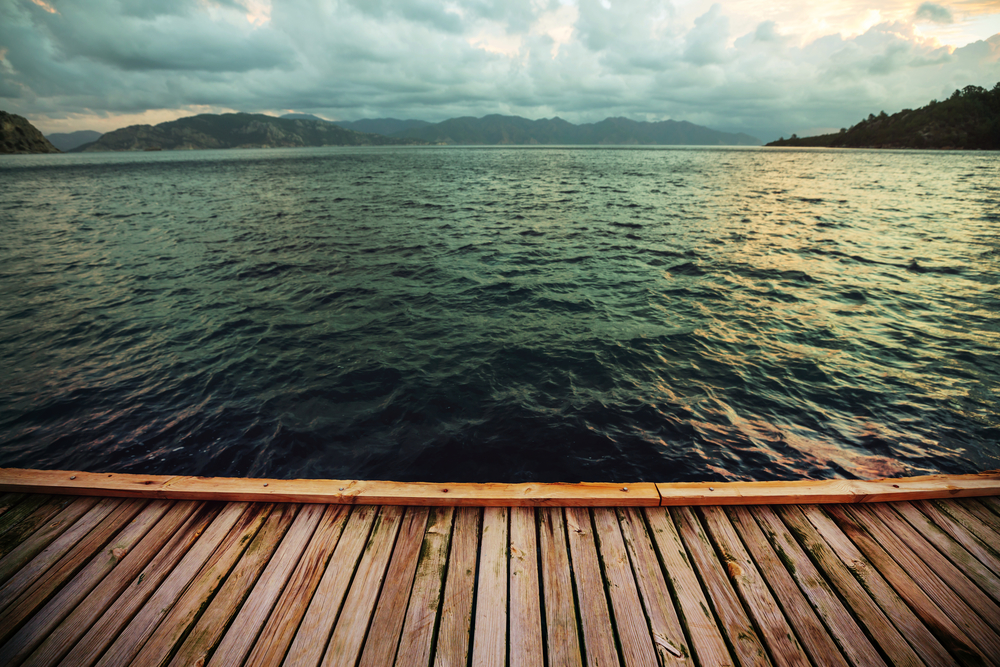 Wooden pier, sea waves and a storm sky. Travel background. Landscapes concept.