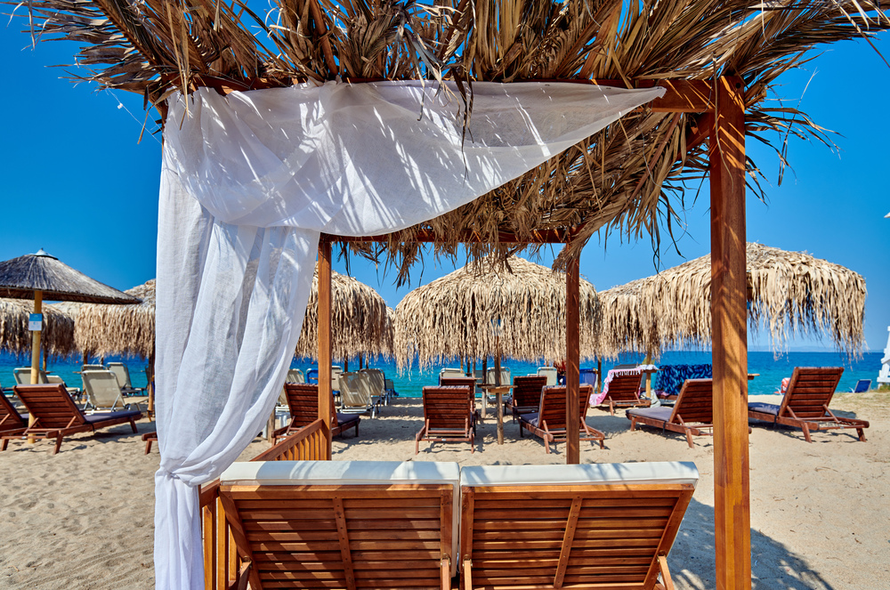 Beautiful beach in Toroni with umbrellas and gazebo, Sithonia, Greece