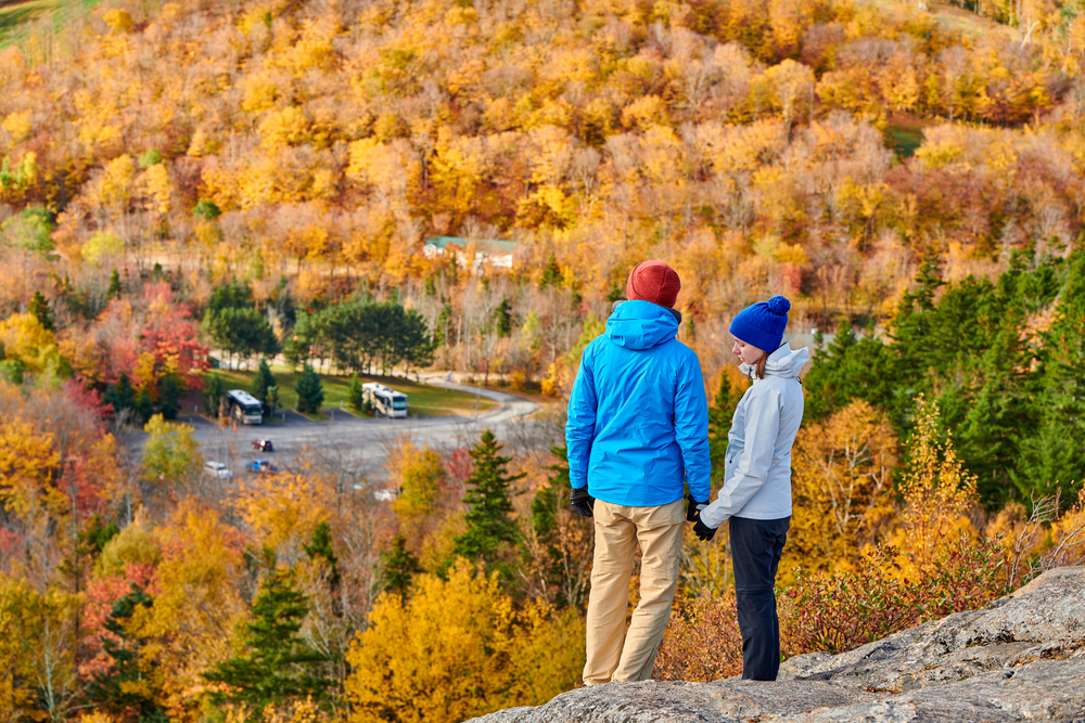 Couple hiking at Artist&rsquo;s Bluff in autumn. Fall colours in Franconia Notch State Park. White Mountain National Forest, New Hampshire, USA