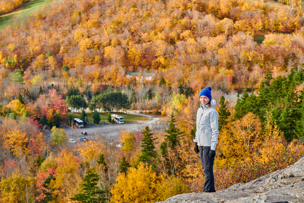Woman hiking at Artist&rsquo;s Bluff in autumn. Fall colours in Franconia Notch State Park. White Mountain National Forest, New Hampshire, USA