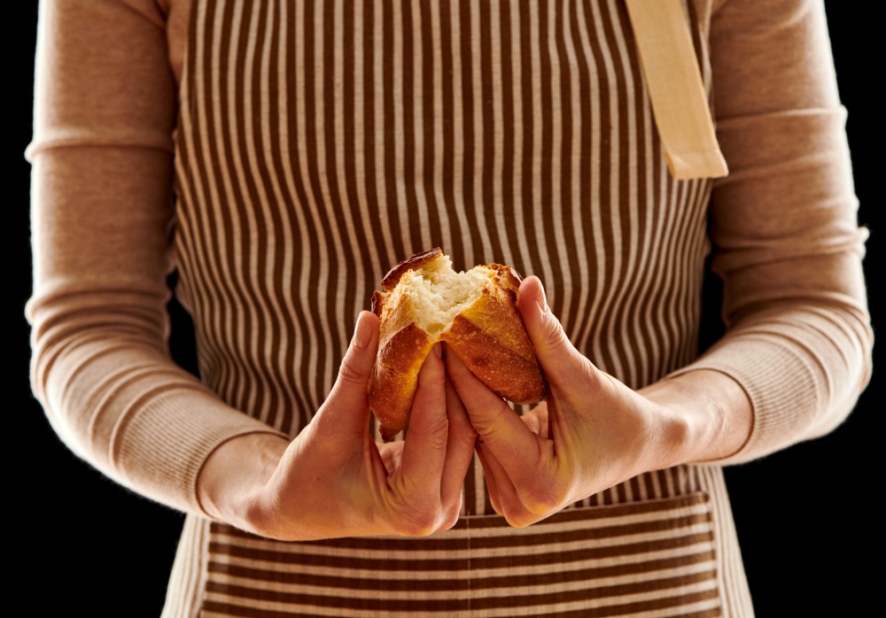 Baker woman holding rustic organic homemade bun in hands