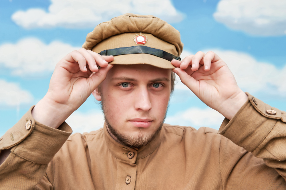 Portrait of soldier in uniform of World War 1 on the background of blue sky. Costume accord the times of World War I. Photo made at cinema city Cinevilla in Latvia. Cockade on the hat do not contain trade mark. ;