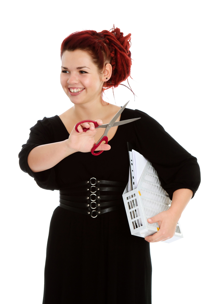 Smiling red-haired accountant with scissors and a folder with documents isolated on white background.