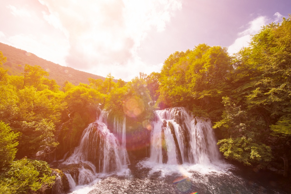 Amazing nature landscape, beautiful waterfall with sunlight in deep summer forest