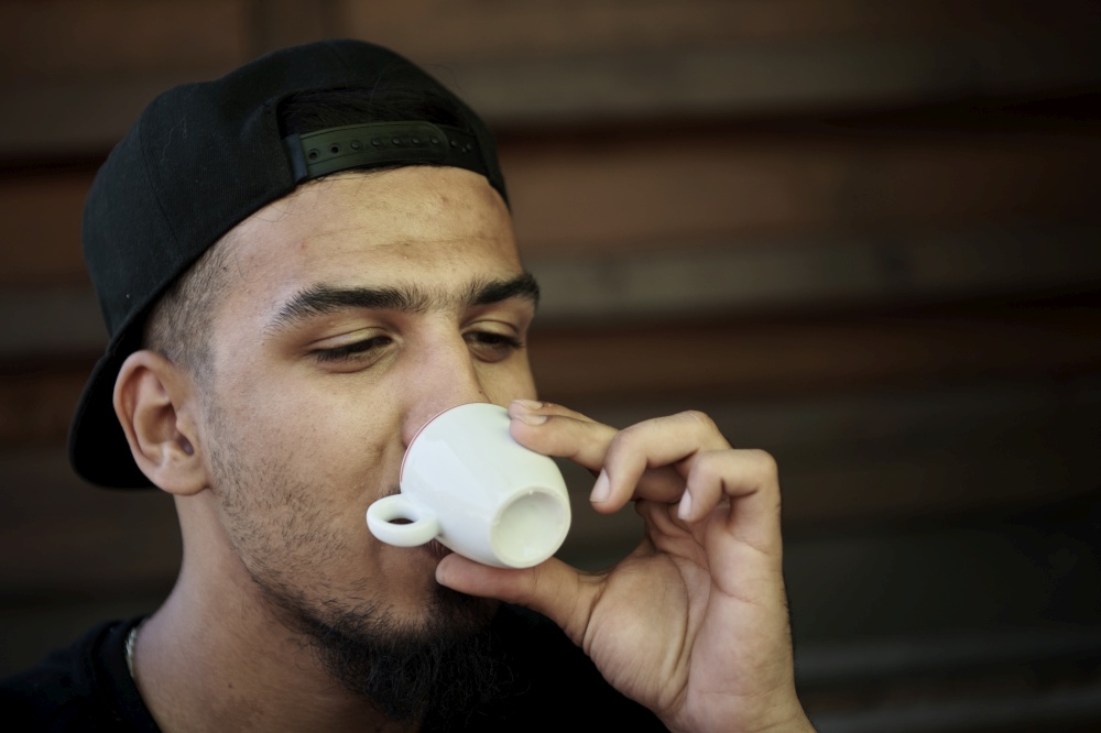 young middle eastern man  drink hot italin coffee